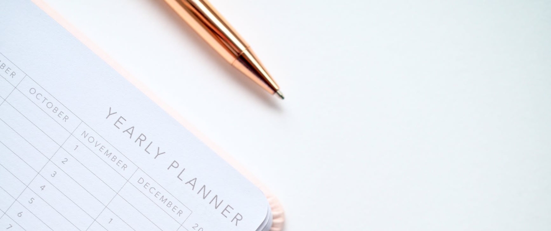 close up photo of yearly planner beside a pen